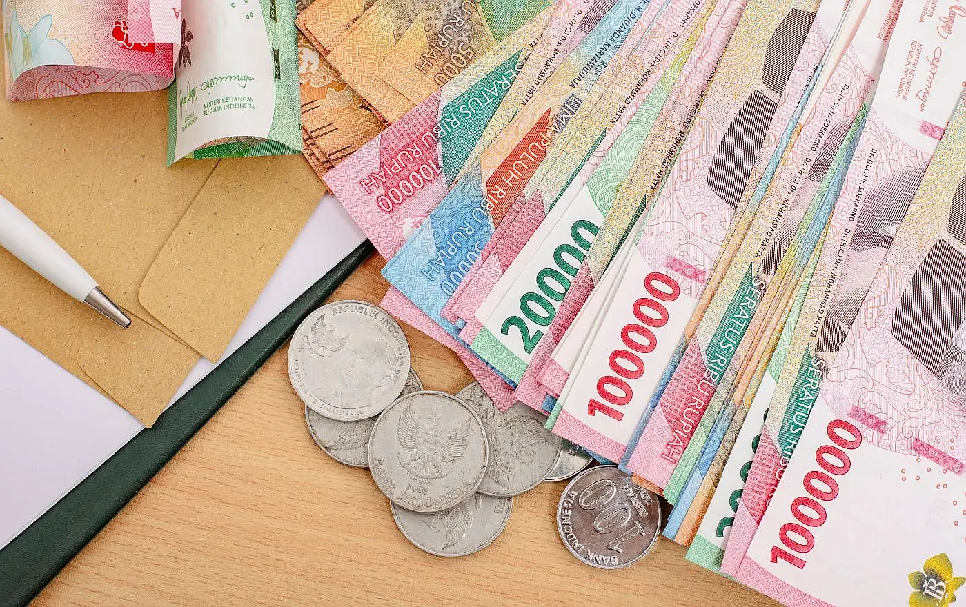 Indonesian Rupiah banknotes and coins of various denominations displayed on a table