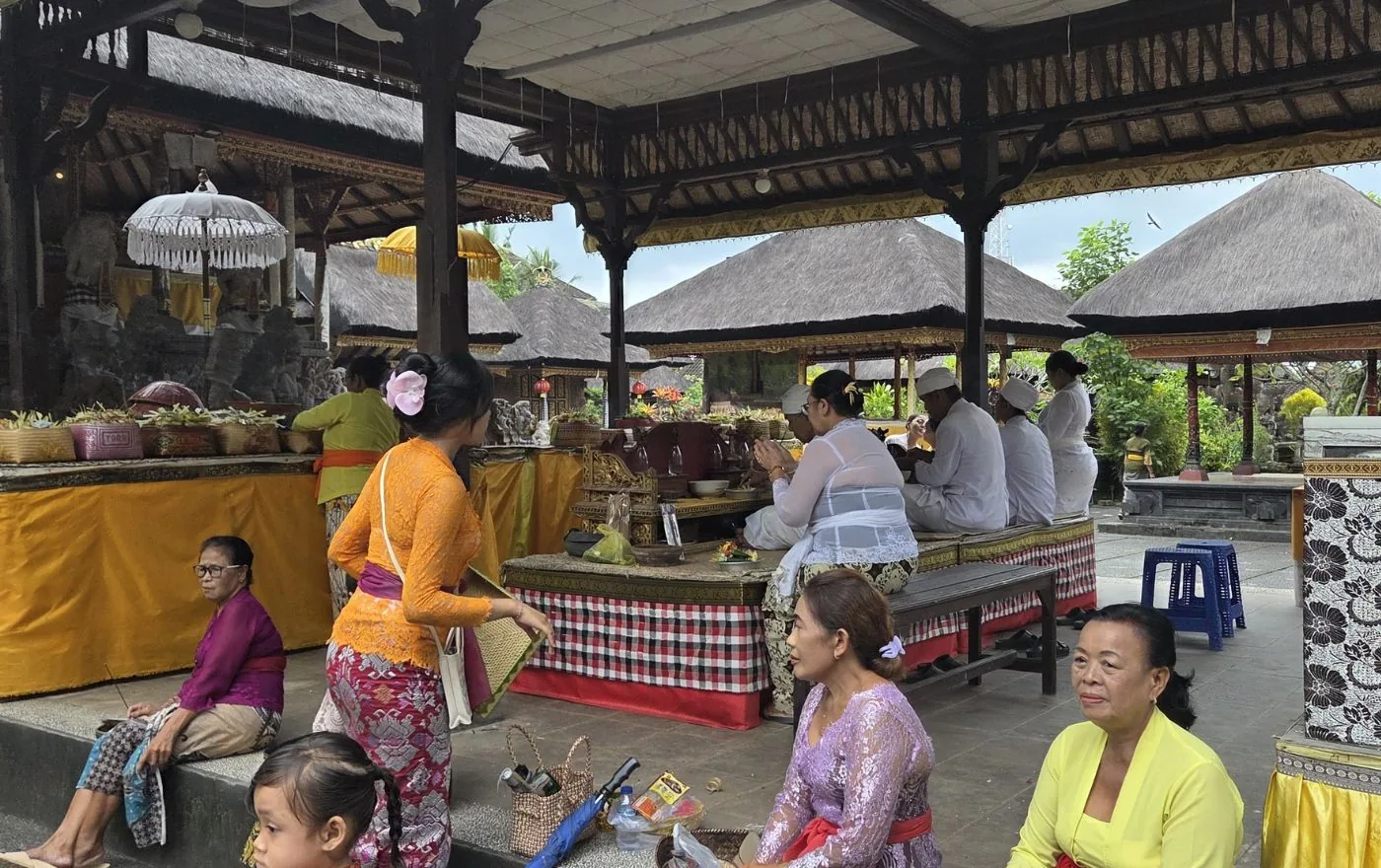 Balinese temple ceremony during Purnama full moon with worshippers, offerings, and incense