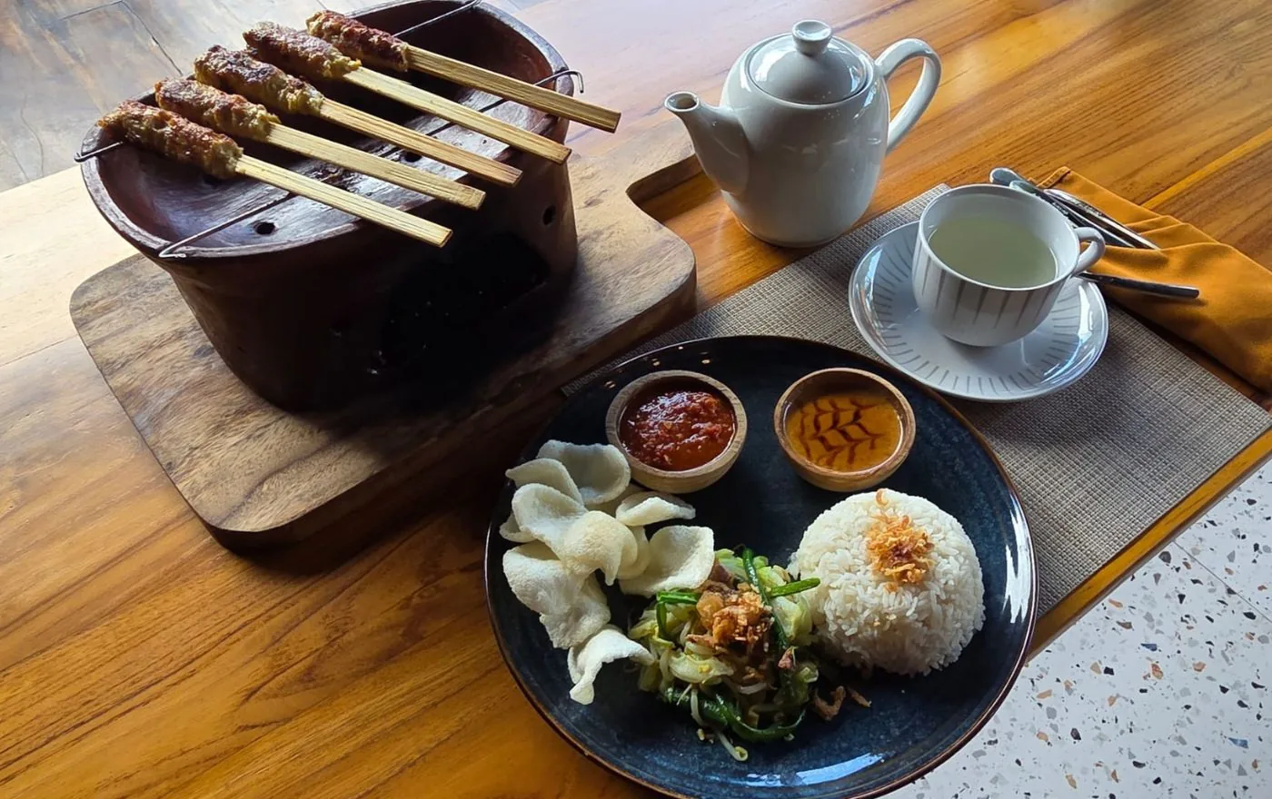 Sate Lilit chicken satay wrapped around lemongrass sticks, grilled and served on a traditional plate