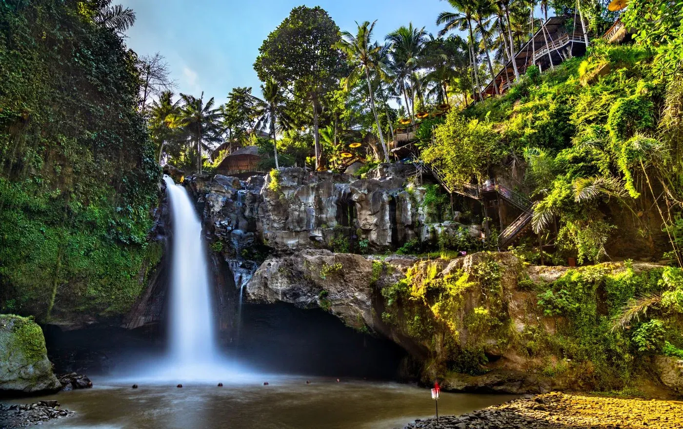 Tegenungan waterfall in Ubud Bali surrounded by lush green tropical jungle during rainy season