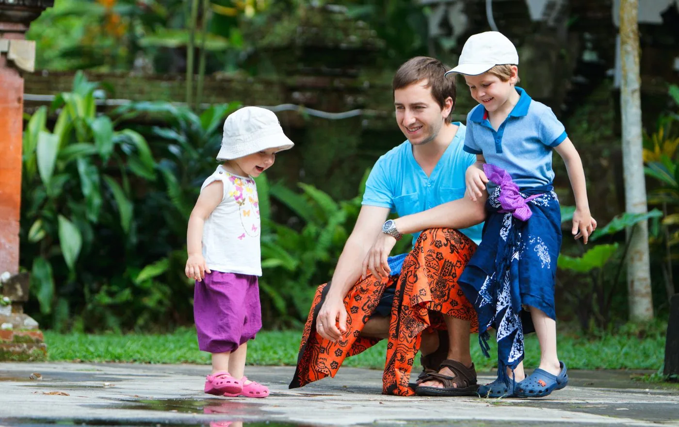 Visitors wearing traditional sarongs and sashes at a Balinese Hindu temple entrance