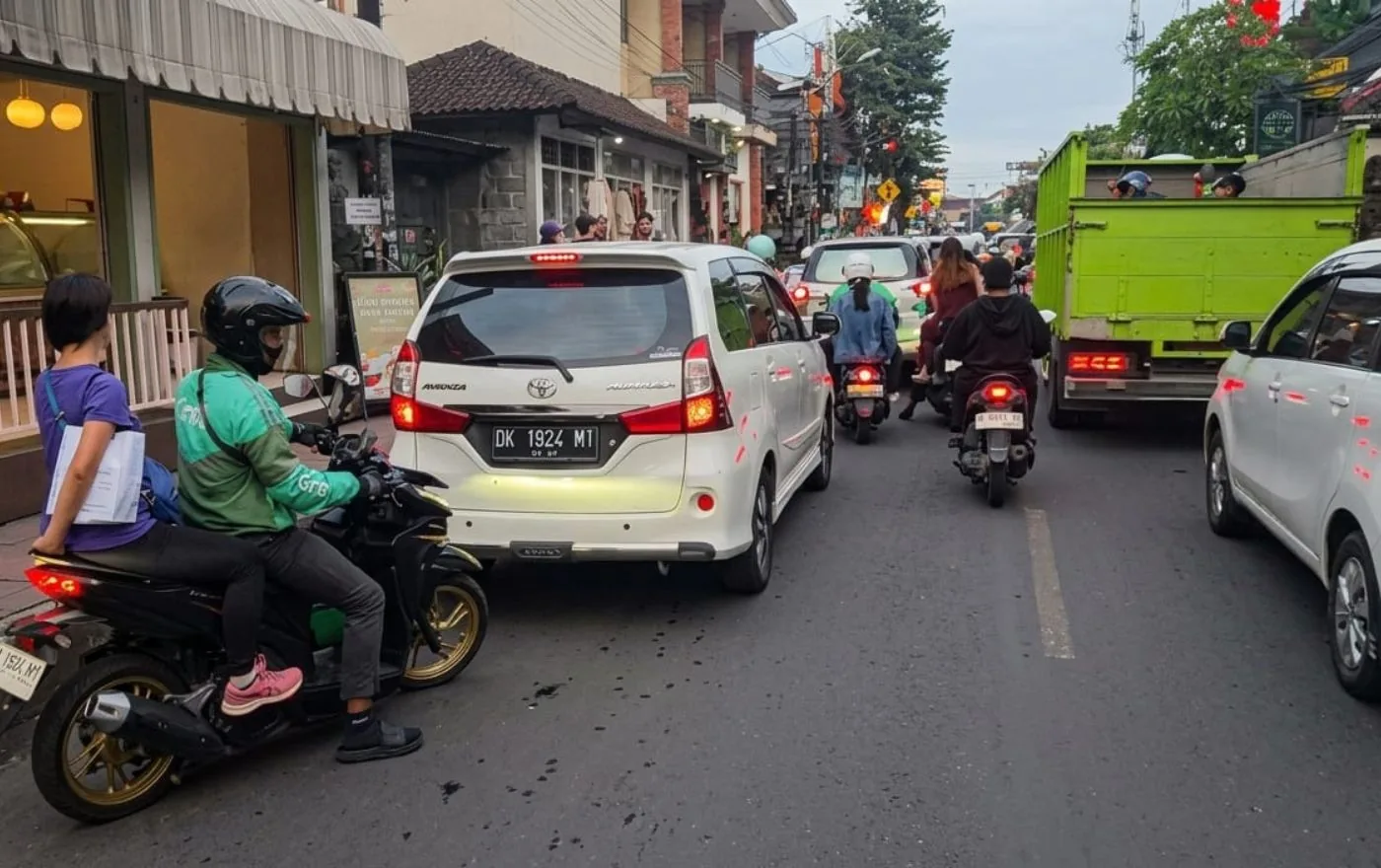 Bali street traffic with Grab motorbike driver and cars in Ubud